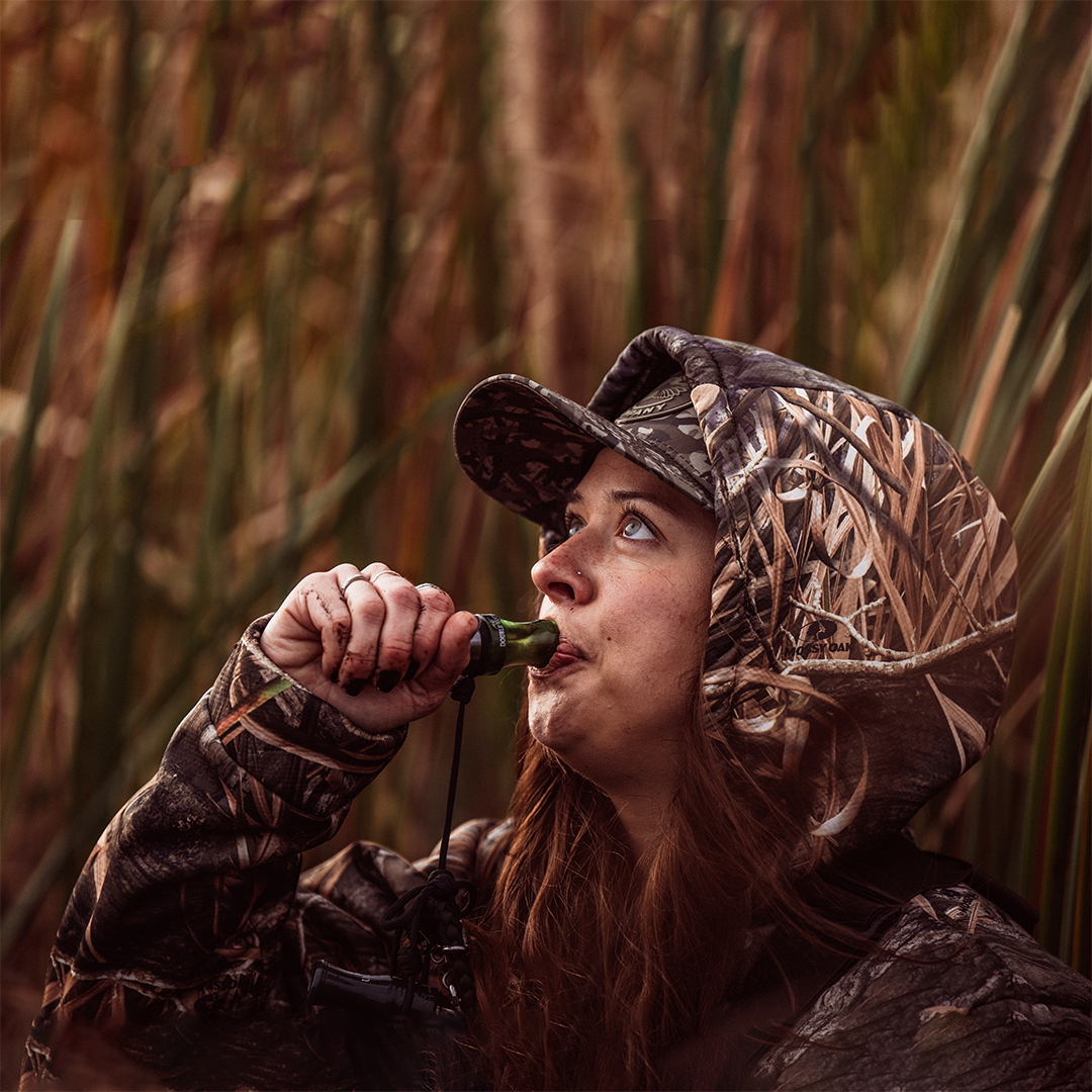 Waterfowl hunter hunting in a blind with their dog